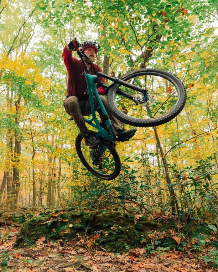 A man jumps through the air on a mountain bike.