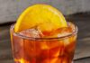 10 Pittsburgh Bars That Have Expansive Non-Alcoholic Offerings A short non-alcoholic cocktail from a Pittsburgh bar in a dark orange color with an orange slice as the garnish.