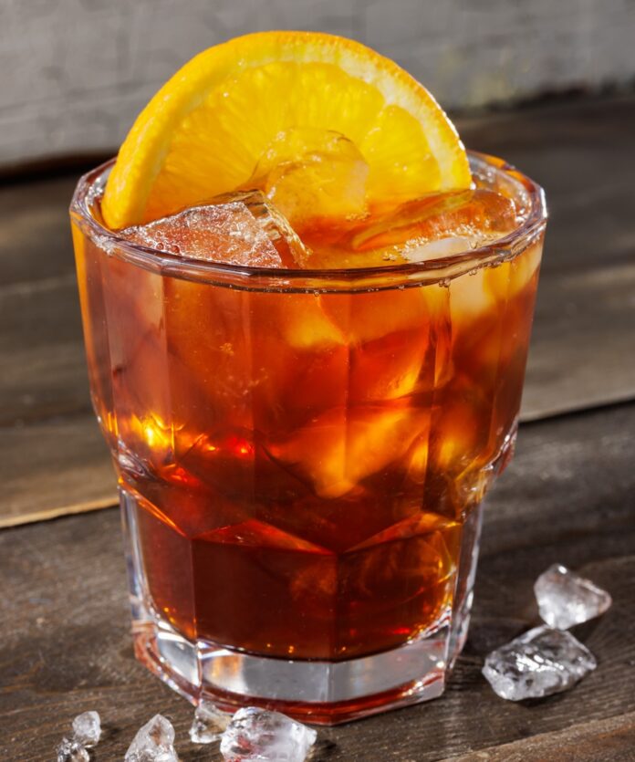 10 Pittsburgh Bars That Have Expansive Non-Alcoholic Offerings A short non-alcoholic cocktail from a Pittsburgh bar in a dark orange color with an orange slice as the garnish.