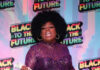 Pittsburgh Black Pride Plans to Show Up and Show Out for Pride Month and Juneteenth A drag queen performs in a purple dress and afro at Pittsburgh Black Pride with dollar bills in her hands.