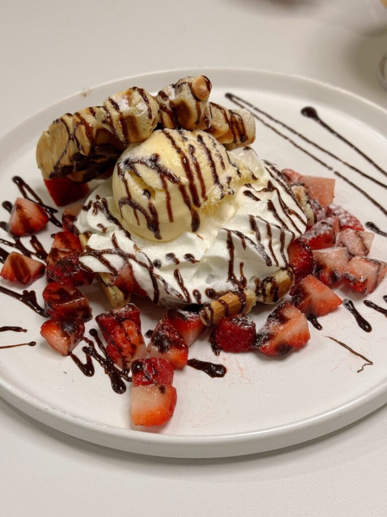 Whipped cream and ice cream on top of a bed of strawberries.