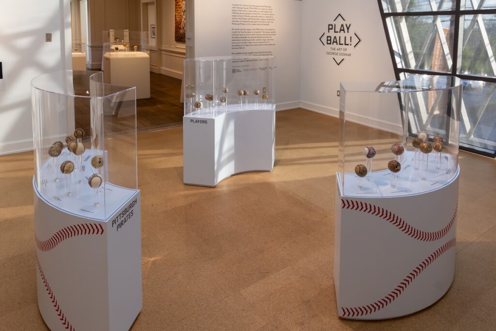 The Play Ball! exhibit at the Westmoreland Museum with baseball stands holding painted baseballs by George Sosnak.