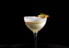 The Peach Thyme Continuum: Clarified Buttermilk Punch A clear clarified buttermilk punch cocktail with a white foam on top.