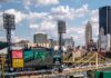 The Ultimate Guide to PNC Park: Parking, Dining, Bag Policy, and More A baseball game with a large crowd inside PNC Park in Pittsburgh with the skyline behind the stadium.