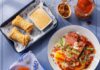 Where to Eat Breakfast in Pittsburgh from Sit-Down to On-the-Go A variety of filipino breakfast dishes on a blue table in two rectangular plates, a round white plate, and a small skillet.