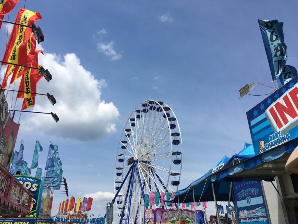 A Ferris wheel in between food booths at the Big Butler Fair.