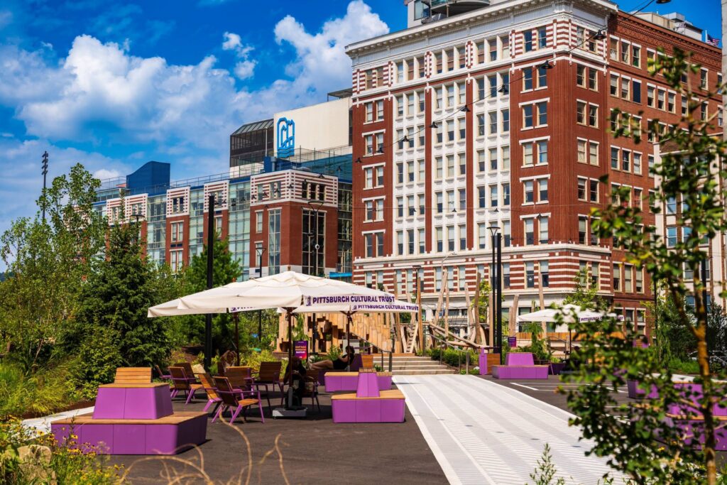Outdoor seating area with Pittsburgh Cultural Trust banner, perfect for Pittsburgh events this weekend.
