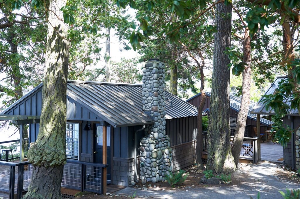 A small cabin in the woods with a stone chimney.
