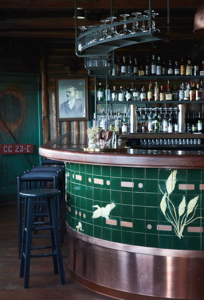 A rounded bar with bottles on the racks behind the bar.