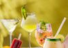 6 Frozen Cocktail Recipes for a Sweltering Pittsburgh Summer A set of six frozen cocktails in various glasses with summery toppings all on a green background.