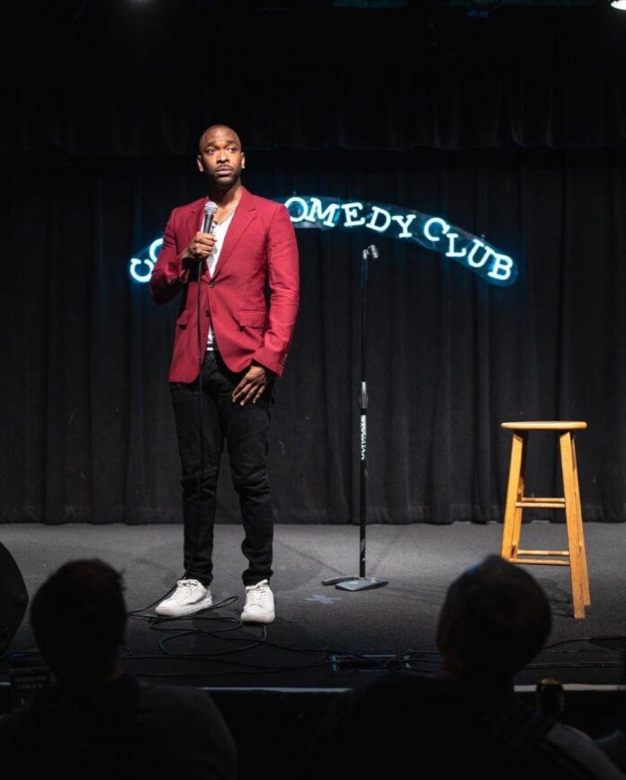 Hot Tickets in Pittsburgh With Sean Collier: July 27-August 2 Jay Pharoah on stage at a comedy club in a red jacket with a mic in his hand.