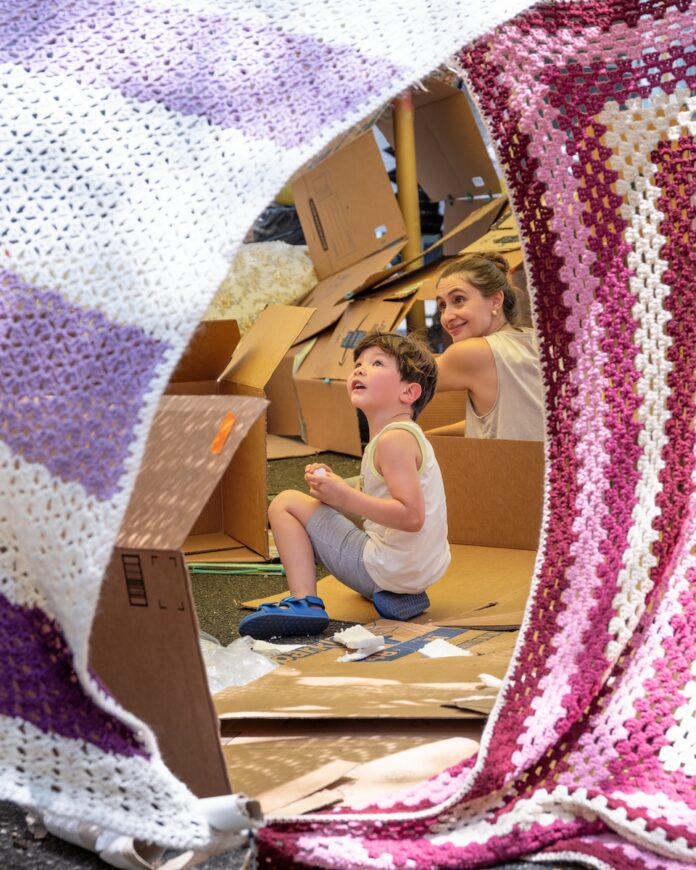 Hot Tickets in Pittsburgh With Sean Collier: July 13-19 A kid crawls inside an art exhibit inside woven carpets of pink, purple, and white on top of pieces of cardboard.