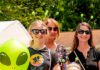 The Truth Is Out There. And So Is the Kecksburg UFO Festival Near Pittsburgh A family stands with alien ears on their heads, holding blow up aliens.