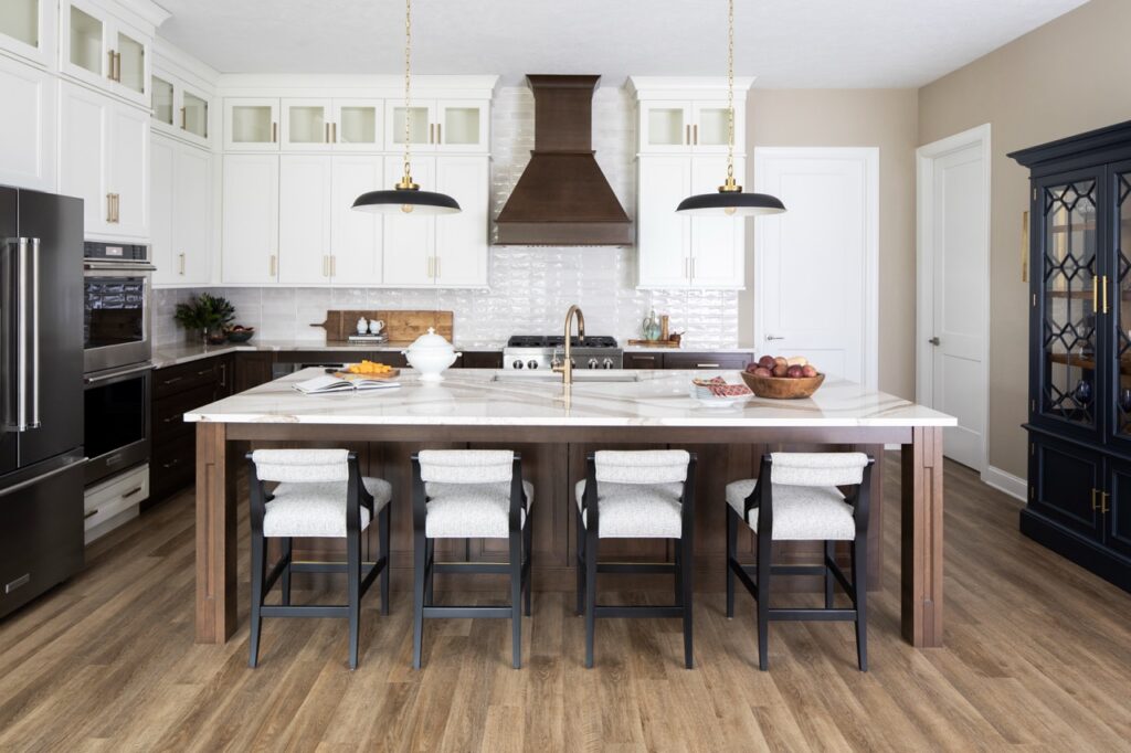 A large marble table with four white chairs in the kitchen.