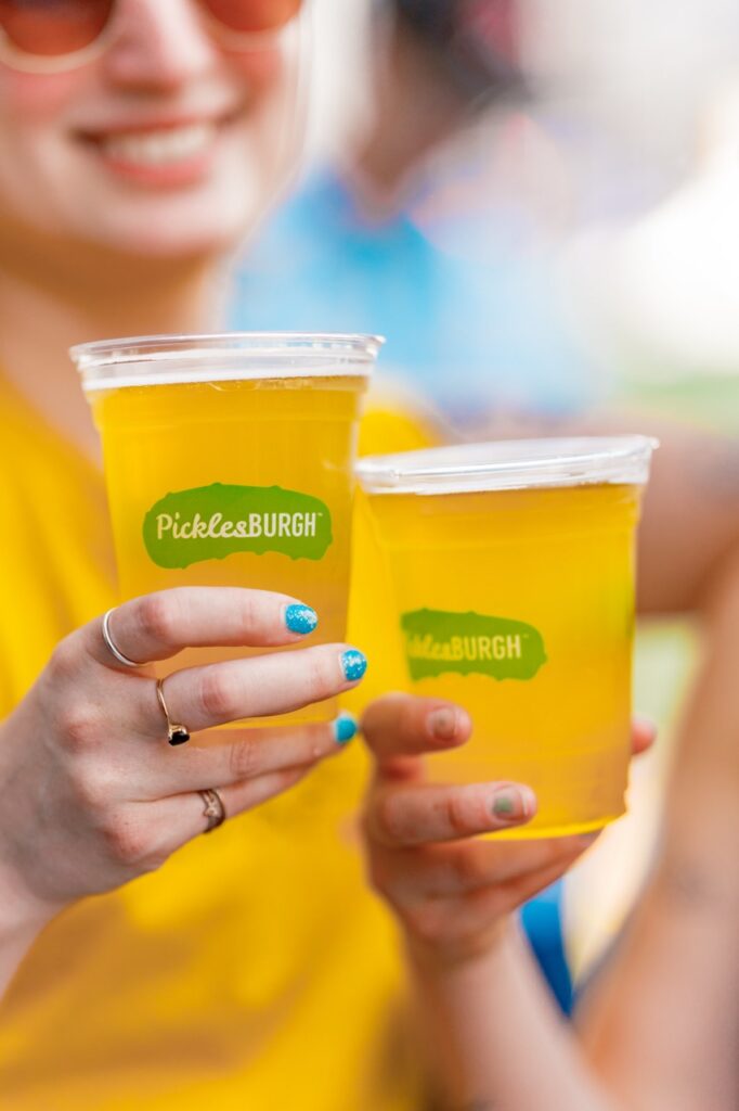 Two women hold Picklesburgh beers.