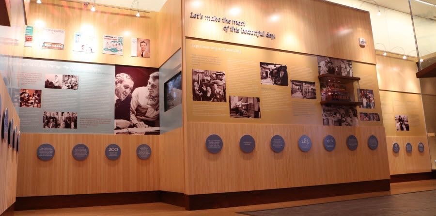 A wall of the Fred Rodger's exhibit with a timeline and pictures.
