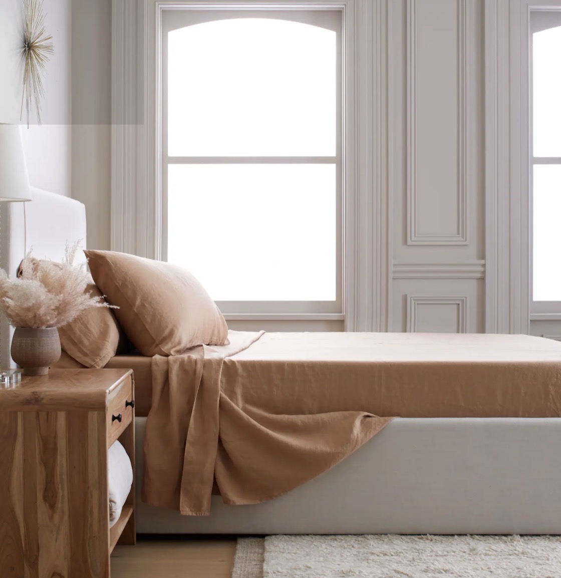A bed with brown sheets on it.