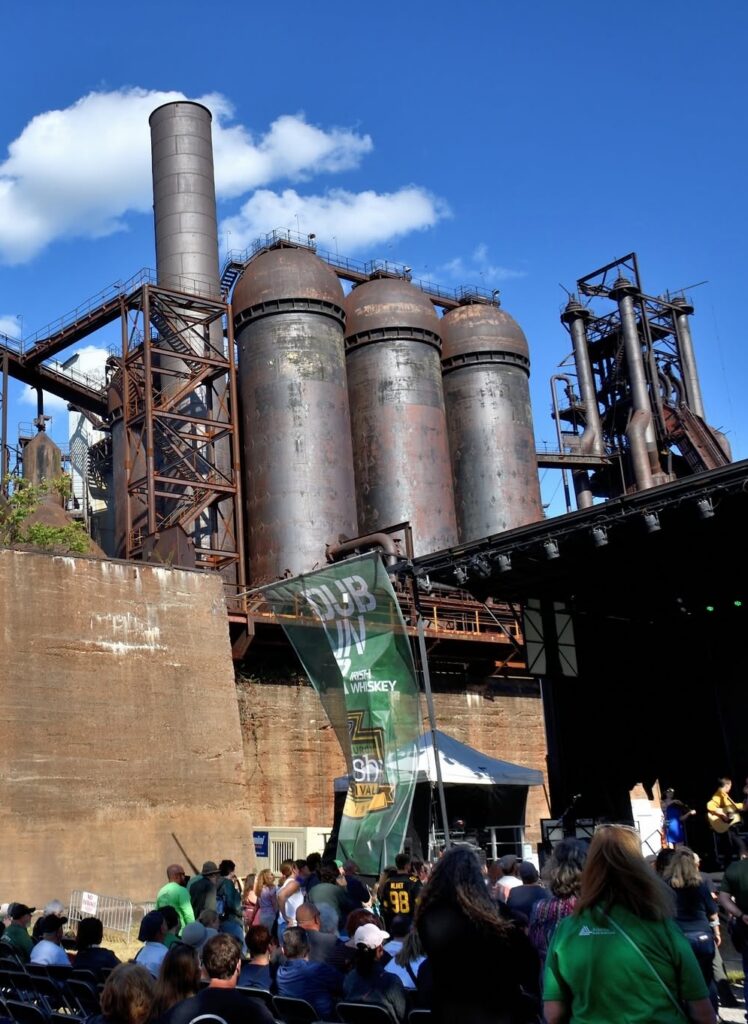 Crowd gathered at outdoor event near historic Pittsburgh industrial site