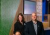 Sarah Heinz House Empowers Pittsburgh Youth Through Programming: Head of the Table, July 2026 Three leaders of Sarah Heinz House with one woman sitting in an orange chair and another woman and man standing behind the chair.