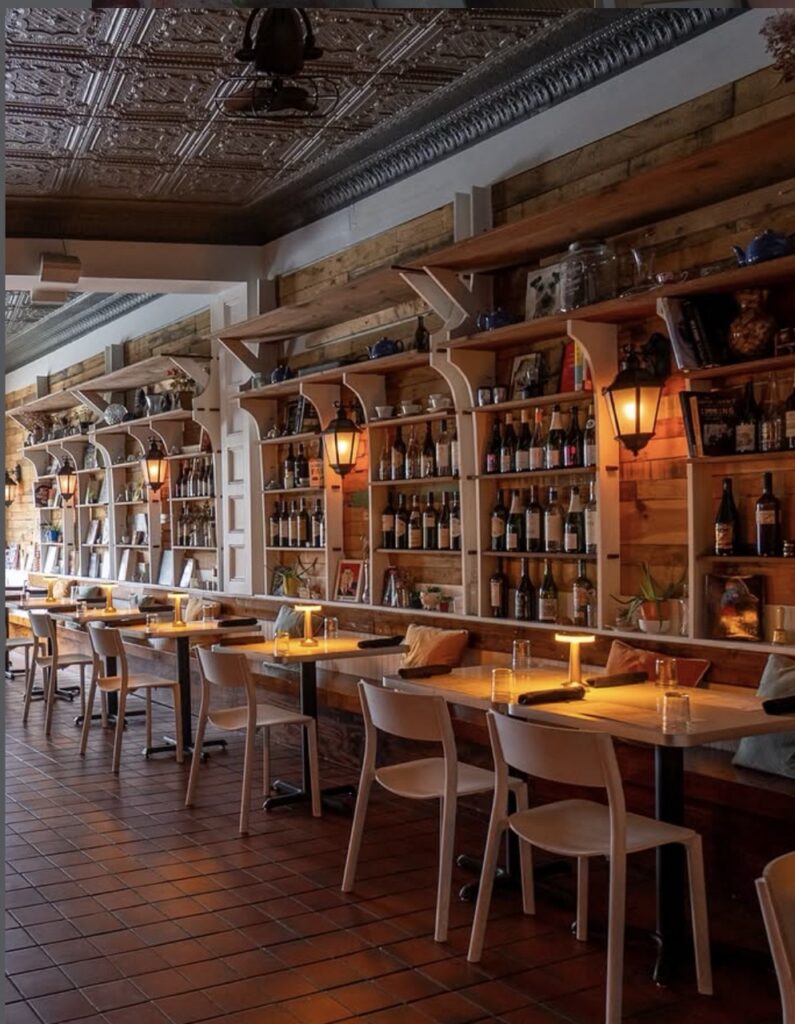 The bar at Scratch and Co. with plenty of shelves of bottles behind it.