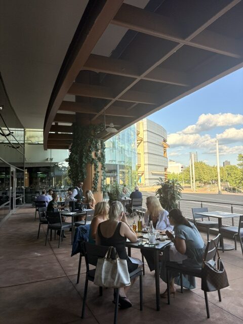 People sitting outside at cafe tables, dining at Rivers Casino in Pittsburgh