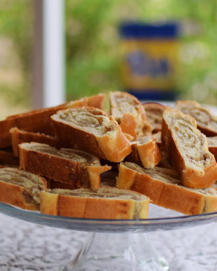 Nut rolls sliced and stacked up on a plate.