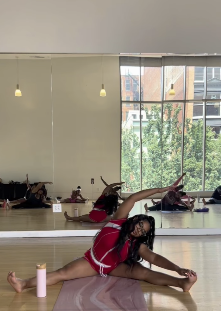 Woman in red stretching during a yoga class in Pittsburgh