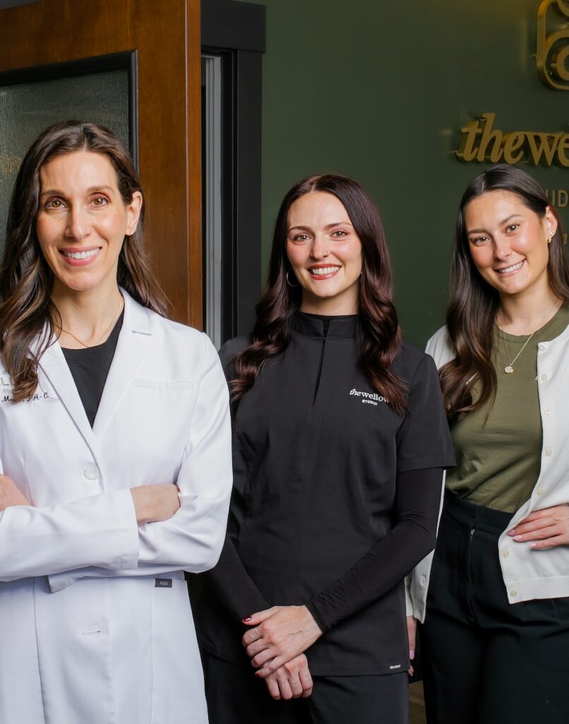 Three medical experts at The Wellow in East Liberty stand in medical jackets.