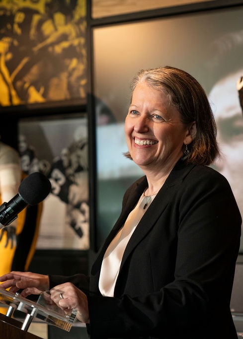 United Way 21 million investment western pennsylvania TABLE Magazine Bobbi Watt Geer in a black jacket talking at an event on a podium.