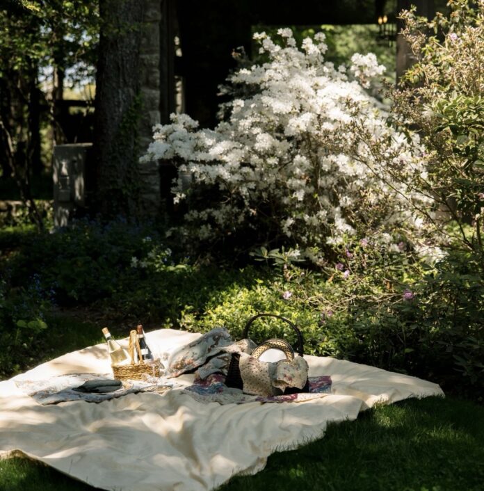 Zodiac Gift Guide: What to Buy a Leo A picnic setting out by a blooming bush.