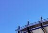 Your Guide to Acrisure Stadium: Bag Policy, Parking, and Other Tips The outside of Acrisure Stadium with park of the high seats and walking tracks in front of a blue sky.
