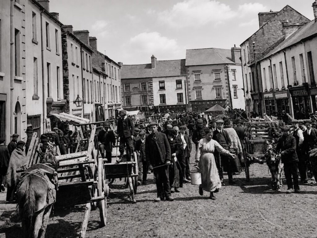 Vintage street market scene with people and horse-drawn carts