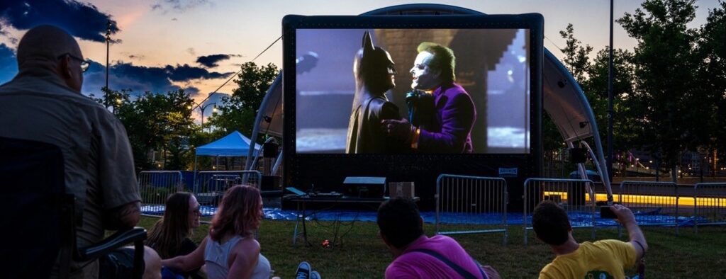 Outdoor movie screening of Batman showing Batman and Joker at a Pittsburgh event.