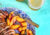 Chipotle Rubbed Pork Tenderloin With Grilled Peaches and Lime Sliced chipotle rubbed pork tenderloin, grill-marked peaches, and lime on a blue speckled plate with a vintage fork.