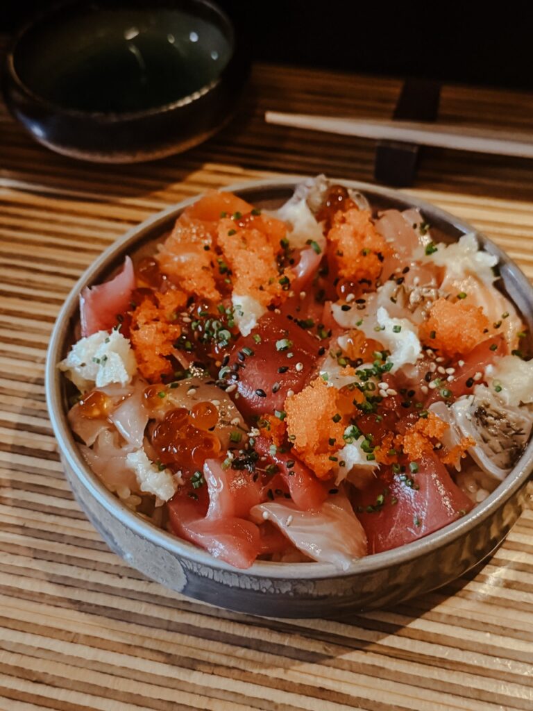 A bowl full of rice with seafood and seasoning.