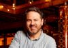 Pittsburgh Historic Whiskey Company H. Obernauer & Co. Returns to the Strip District After More Than a Century Matthew stands at a bar with his arms on the table.