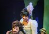 How to Appreciate a Musical for a Deeper Theater Experience Live musical theater scene with a male actor sketching at an easel and a smiling actress in a white period dress.