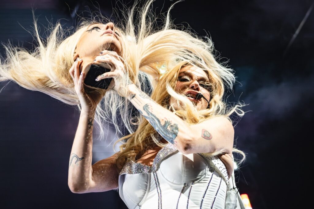 Kesha on stage swinging around a mannequin head.