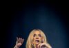 Kesha at The Pavilion at Star Lake: What to Know Before You Go Kesha in a white corset on stage with a mannequin head of herself below her.