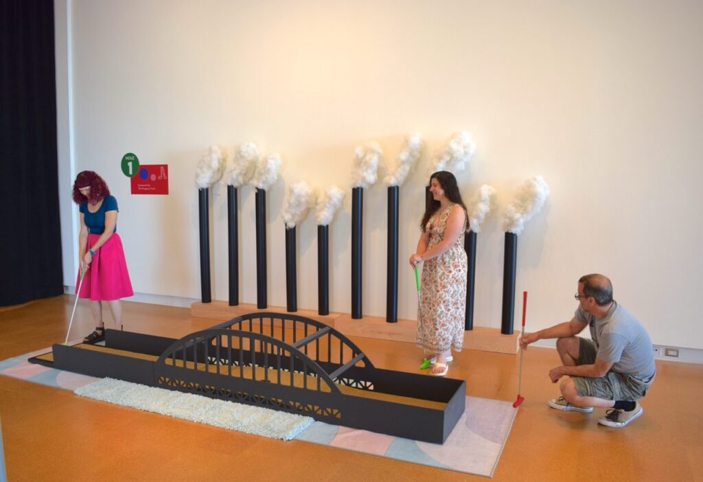 People play putt-putt on a bridge course inside the museum.