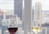 Monterey Bay Fish Grotto Celebrates 30 Years of Serving Pittsburgh’s Best Views and Seafood A table with food and wine in front of a window with a view of the city skyline in Pittsburgh.