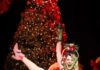 The Most Anticipated Pittsburgh Theater Shows Coming This Fall and Winter 2026 A woman in Who's Holiday kicks her leg up with a wine glass in her hand and a Christmas tree behind her.