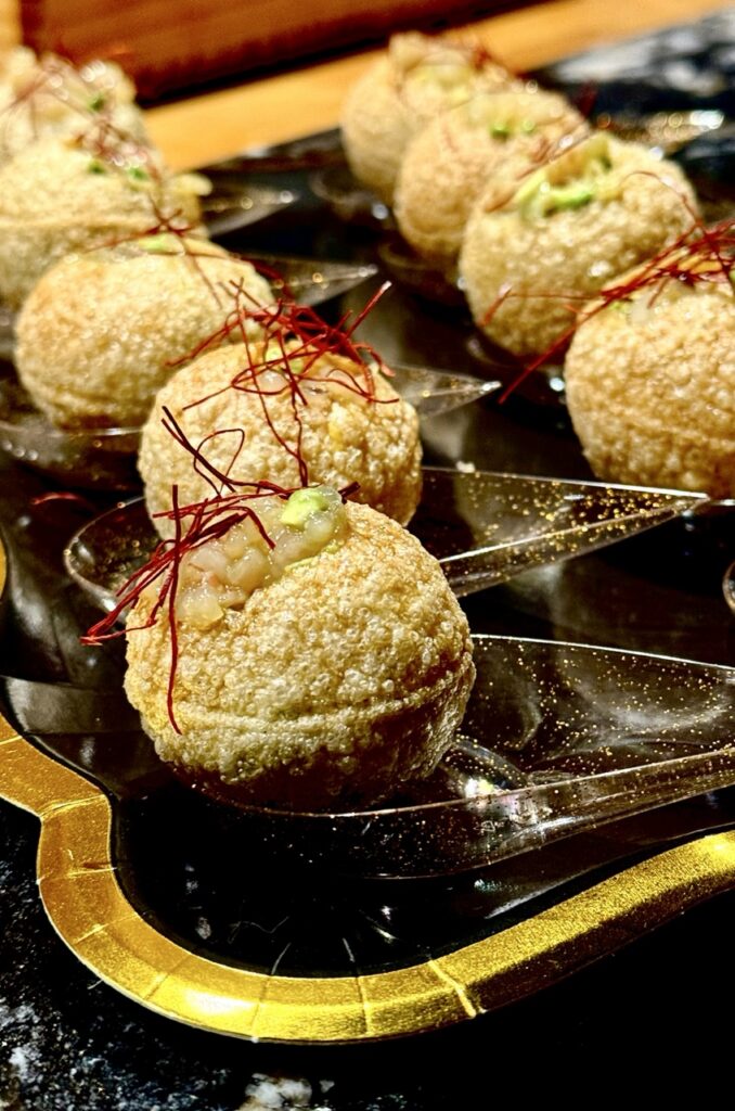 Small fried balls with sprigs of red herbs on top.