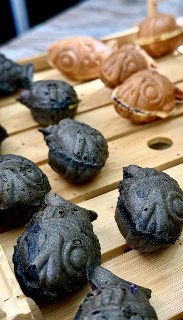 Small Taiyaki fish pastries on a wood board.