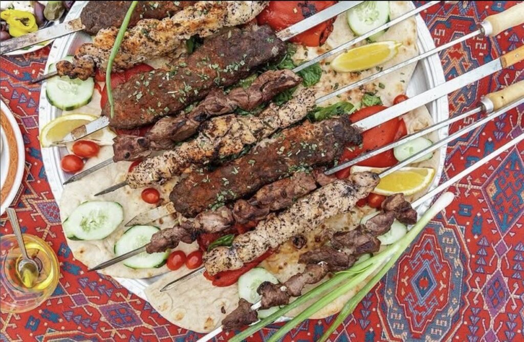 Meat skewers sit on a table.