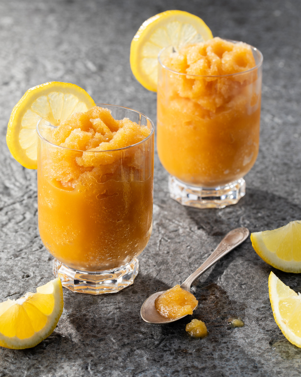A pair of bourbon slush cocktails on a grey background