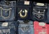 Best Thrift Stores in Pittsburgh for Vintage, Consignment & Resale Pairs of folded vintage jeans in light blue, dark blue, and hot pink.