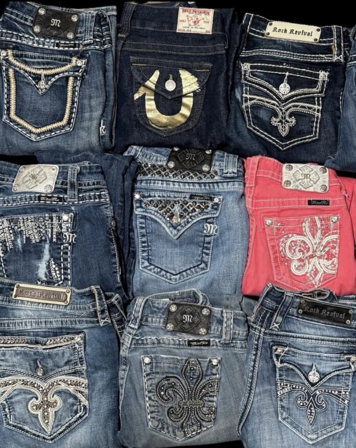 Pairs of folded vintage jeans in light blue, dark blue, and hot pink.