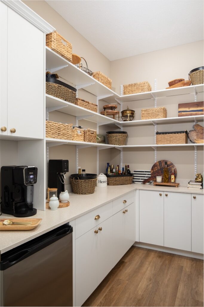 Custom pantry organization with white cabinets, open shelving, and woven baskets.