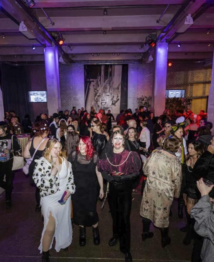 People in costumes at a Halloween party with purple lighting